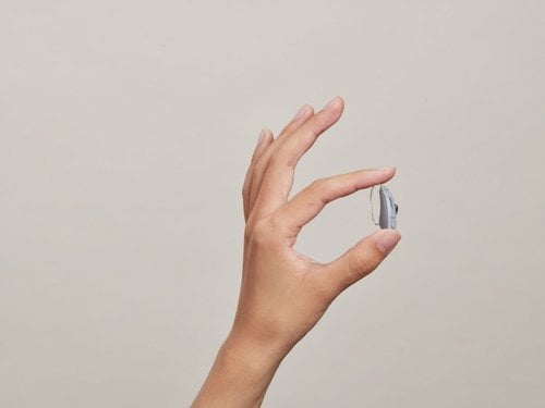 Photo of a Bose SoundControl hearing aid being held in hand